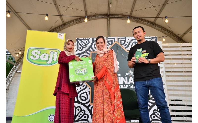 Ketua Pemasaran Delima Oil Products Sdn Bhd, Fatin Sarjat (tengah) menyampaikan sumbangan pek makanan kepada salah seorang ahli keluarga asnaf.