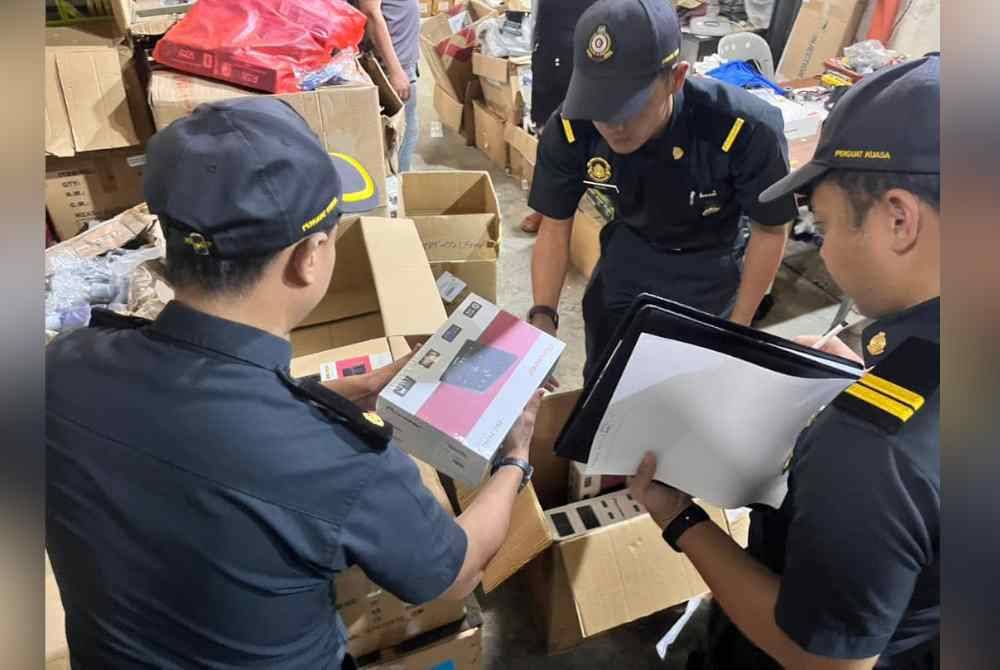 Anggota penguatkuasaan KPDN Sarawak memeriksa barangan elektronik kenderaan tiruan di Taman Perindustrian Demak Laut ketika serbuan pada Selasa. - Foto: FB KPDN Sarawak