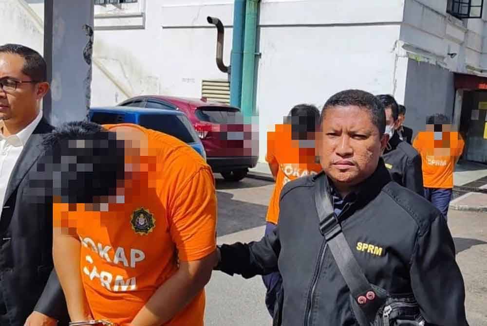 Tiga anggota polis dibawa keluar dari Mahkamah Majistret Johor Bahru selepas selesai permohonan reman bagi membantu siasatan berhubung dakwaan menerima dan meminta rasuah. - Foto: SPRM Johor