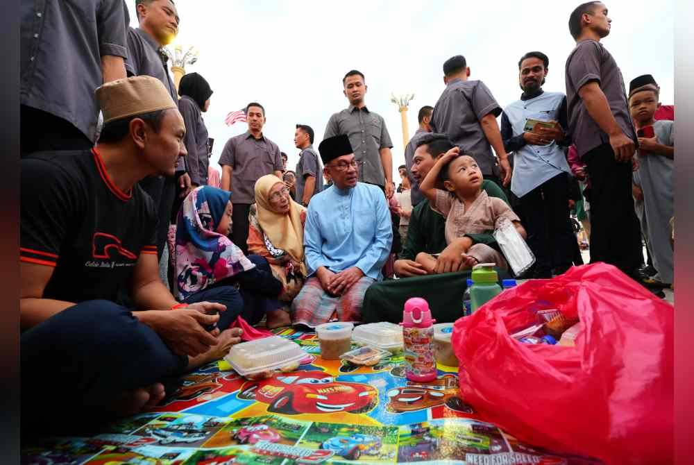 Anwar (tengah) dan Wan Azizah menyantuni orang ramai yang hadir pada Majlis Iftar Madani bersama Perdana Menteri di Dataran Putra Presint 1 Putrajaya hari ini. Foto Bernama