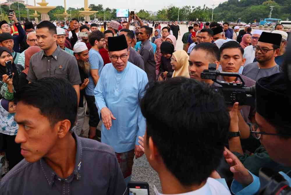 Anwar (tengah) dan Dr Wan Azizah menyantuni orang ramai yang hadir pada Majlis Iftar Madani bersama Perdana Menteri di Dataran Putra Presint 1 Putrajaya hari ini. Foto Bernama