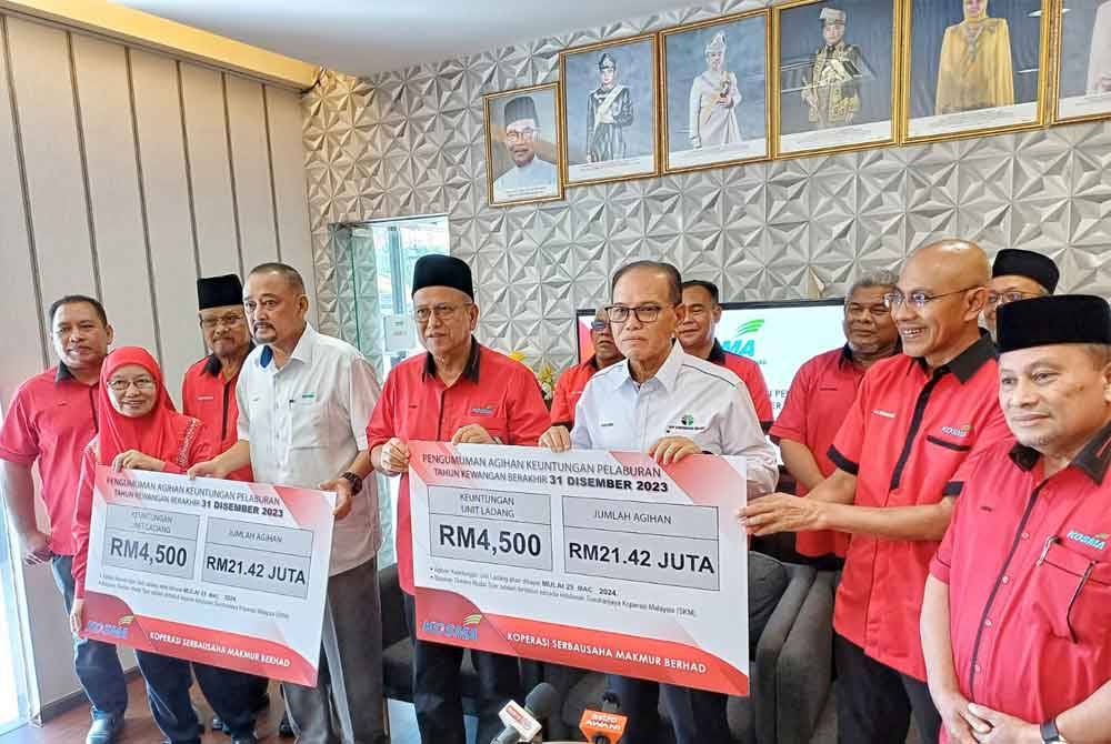 Wan Rosdy (tengah) menunjukkan replika pengagihan bayaran Keuntungan Kosma Tahun 2023 pada Jumaat.