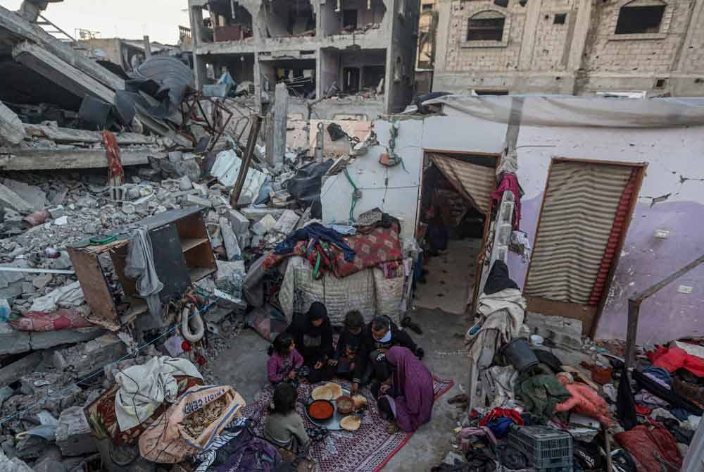 Ahli keluarga Rabaya berbuka puasa di tengah-tengah runtuhan rumah mereka, yang musnah akibat serangan Israel, semasa bulan suci Ramadan di Rafah pada Sabtu lepas di tengah-tengah pertempuran berterusan antara Israel dan pejuang Hamas. Foto AFP