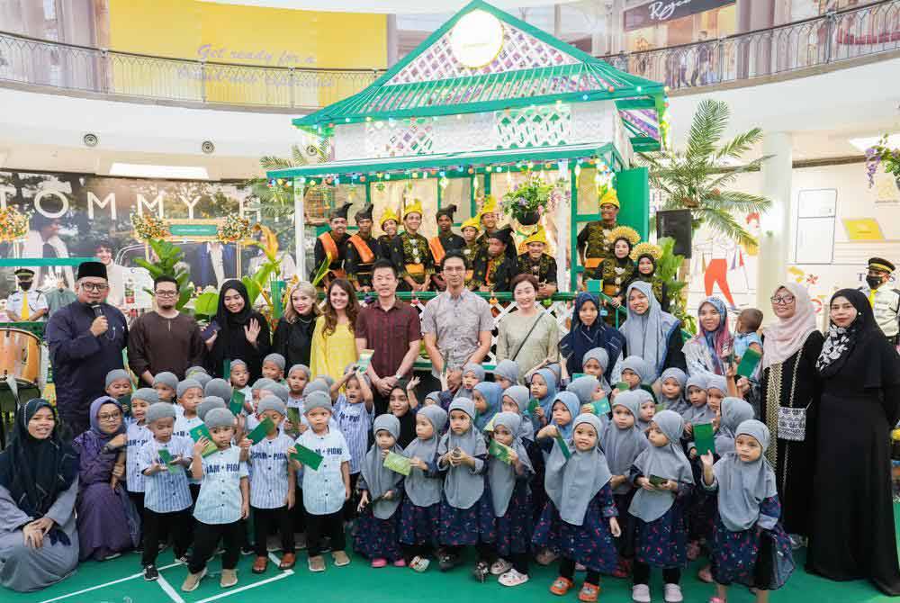 Francis (enam dari kiri) dan Junaidy (tujuh dari kanan) bergambar kenangan bersama anak yatim dan kurang bernasib baik dari Pertubuhan Warisan Suci yang diraikan sempena Aidilfitri.