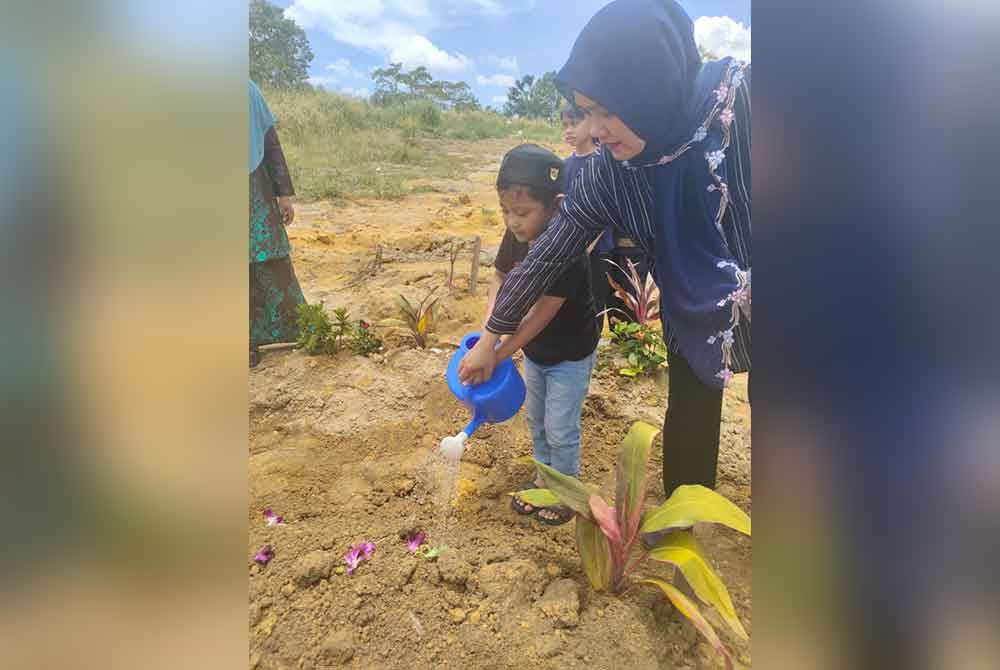 Ayu bersama Eusuf menyiram air di pusara Mila Sharmila di Tanah Perkuburan Islam Banang Jaya, Batu Pahat.