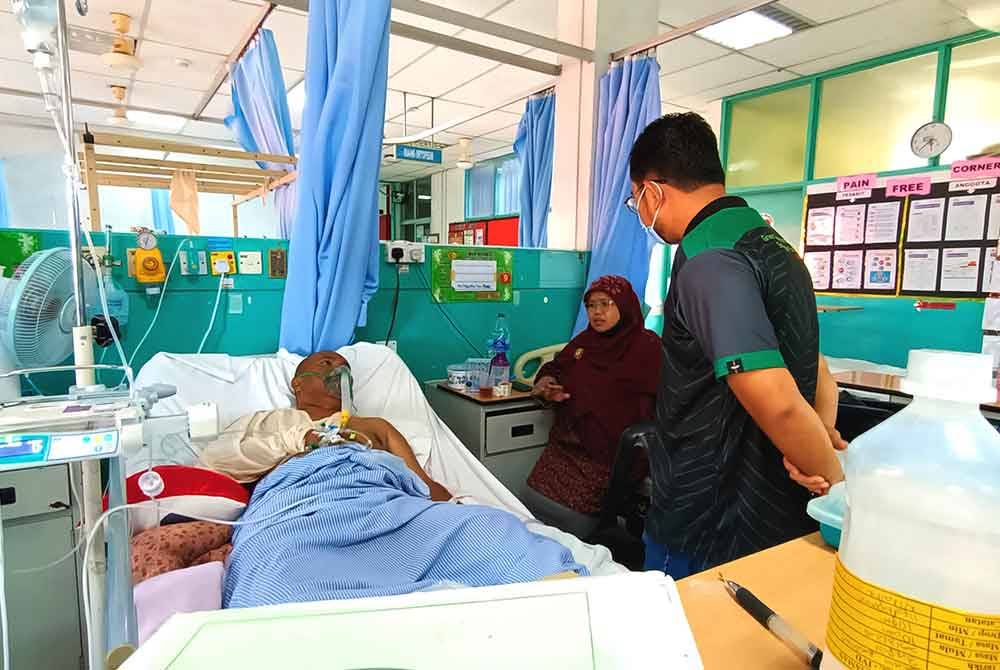 Ahmad Shahdan (kanan) bertanyakan keadaan Sa&#039;ari ketika melawat anggota Perhilitan itu di Hospital Kemaman pada Jumaat.