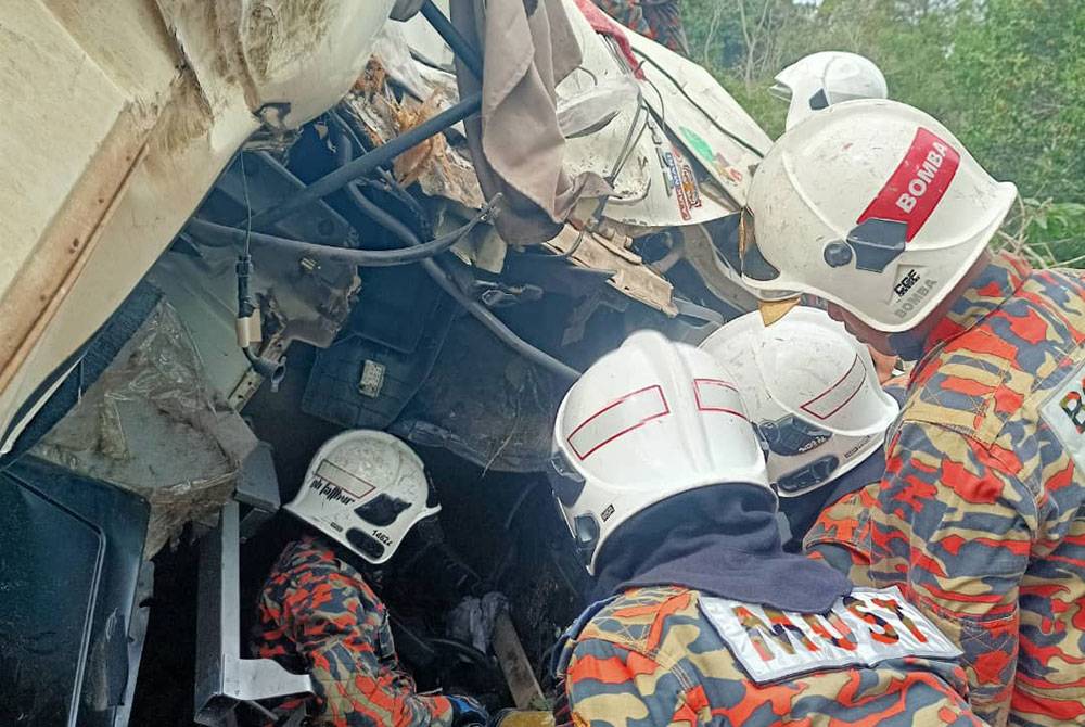 Pasukan bomba menjalankan operasi mengeluarkan seorang mangsa tersepit dalam treler. Foto bomba