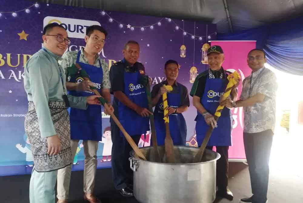 Anuraj (kanan) bersama rakan sinergi menyempurnakan gimik perasmian program bubur lambuk pada Sabtu.