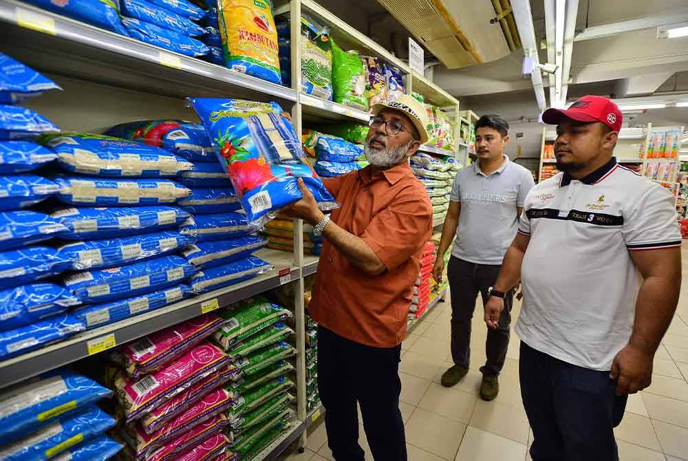 Syed Abu Hussin (dua dari kanan) bersama media membuat pemeriksaan beras secara rawak di tiga premis pada Ahad. - FOTO: SINAR HARIAN/ASRIL ASWANDI SHUKOR.