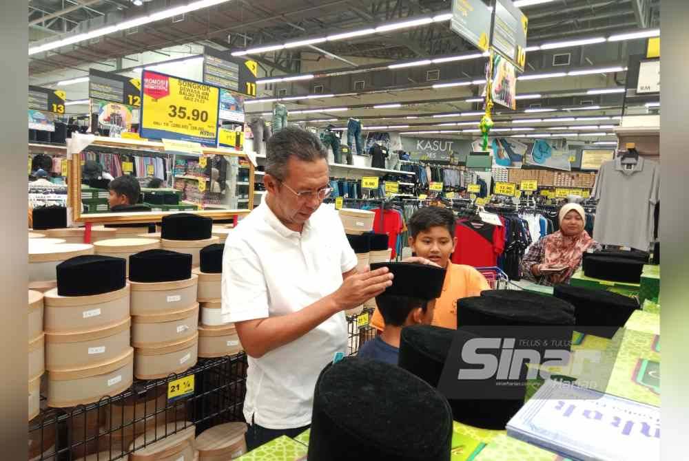 Saiful Yazan turut membantu anak-anak terlibat memilih songkok.