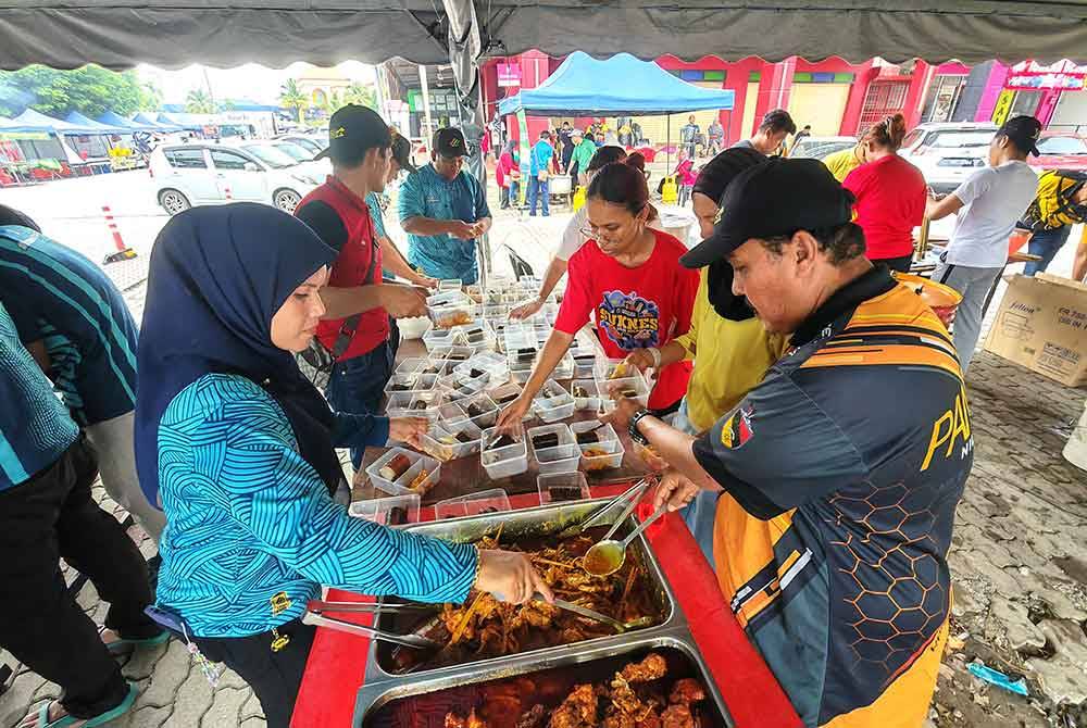 Petugas Pantas bergotong-royong menyiapkan bungkusan pek makanan berisi lemang dan rendang