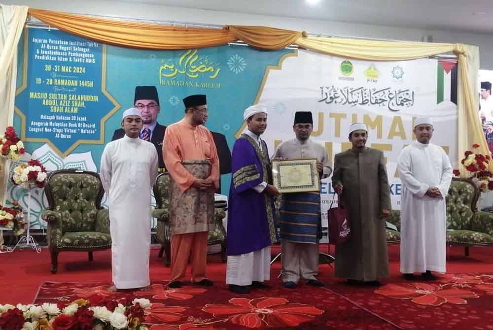 Mohd Shahzihan (tiga dari kanan) menyampaikan sijil syahadah 30 juzuk kepada salah seorang huffaz.