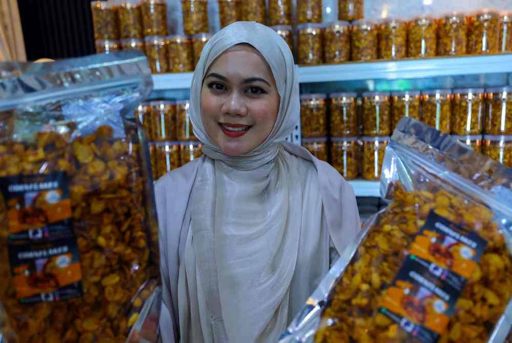 Nurul Arfiqah menunjukkan produk kudapan pedas berasaskan emping jagung di kediamannya di Kampung Senari, Jalan Bako, Kuching baru-baru ini. Foto Bernama