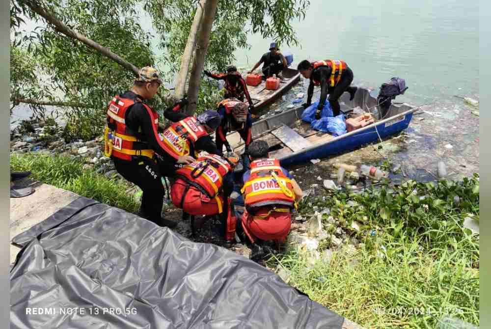 Anggota JBPM membawa naik mayat Juliana yang ditemukan setelah hilang dibawa arus deras ketika menjala ikan di saliran longkang monsun di Kota Perdana, Seri Kembangan, Selangor pada Ahad. Foto Ihsan JBPM