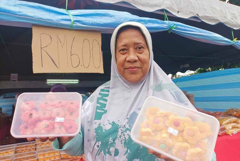 Khairruni menunjukkan biskut raya RM6 yang dijual di gerainya di lot parkir Stesen Minyak Shell di Jalan Hospital, Ipoh sempena Aidilfitri ini.