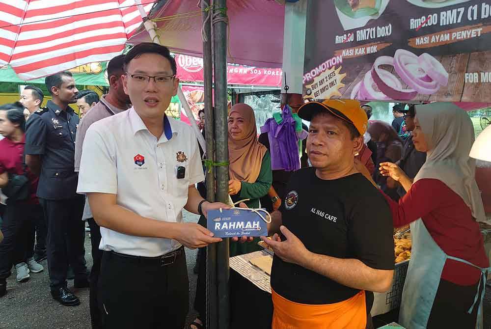 Ting Han (kiri) ketika melakukan tinjauan mesra dengan bertemu orang ramai dan peniaga di Bazar Ramadan Taman Perling, Johor Bahru pada petang Isnin.