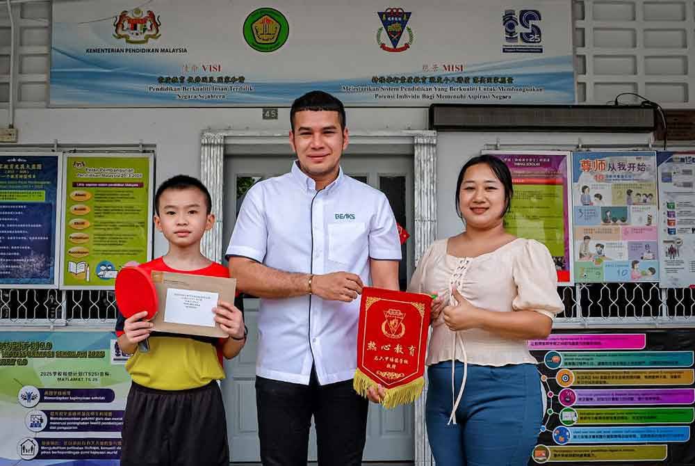 Muhammad Fikri (tengah) bergambar bersama Wei Yeow (kiri) dan Xiao Tong (kanan) selepas penyerahan sumbangan berkenaan.