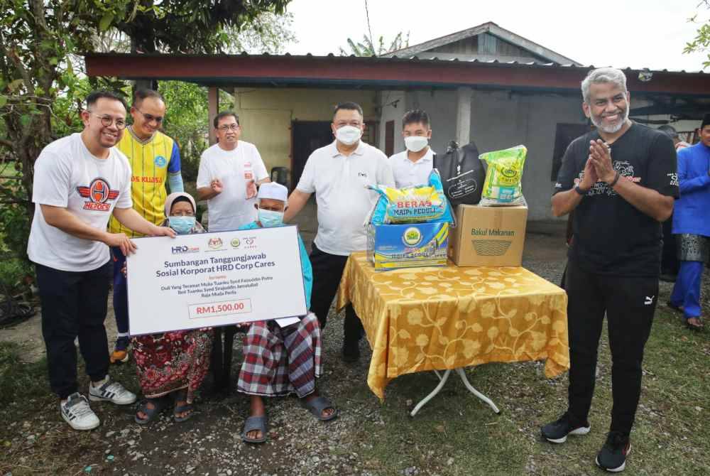 Dari kiri, Steven Sim Chee Keong, Khairul Dzaimee, Muhd Khair Razman, Syed Faizuddin, anakanda Raja Muda Perlis, Syed Sirajuddin Areeb Putra Jamalullail dan Shahul Dawood bergambar bersama keluarga asnaf yang menerima bantuan.