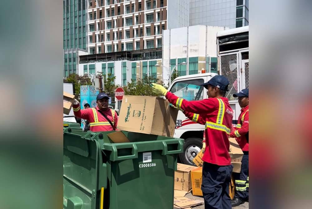 Pekerja mengutip sisa pepejal di kawasan konsesi Alam Flora.