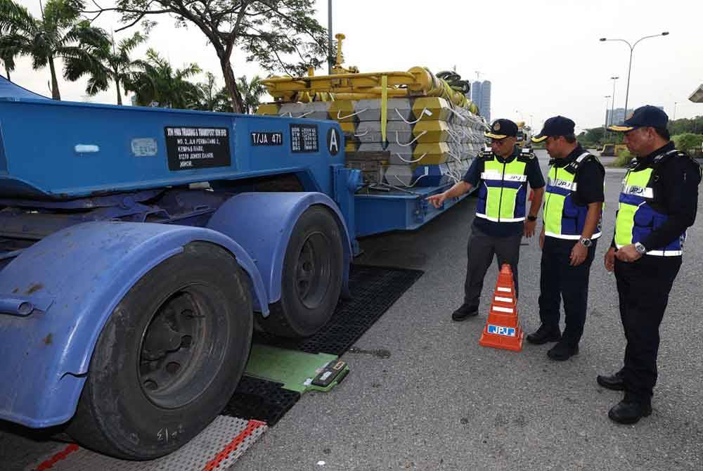 Lokman (tiga dari kanan) melihat kerja-kerja pemeriksaan berat kenderaan lori dengan muatan yang dibawa sempena Ops Khas Hari Raya Aidilfitri 2024 di Rehat & Rawat Pandan pada Selasa. - Foto: Bernama