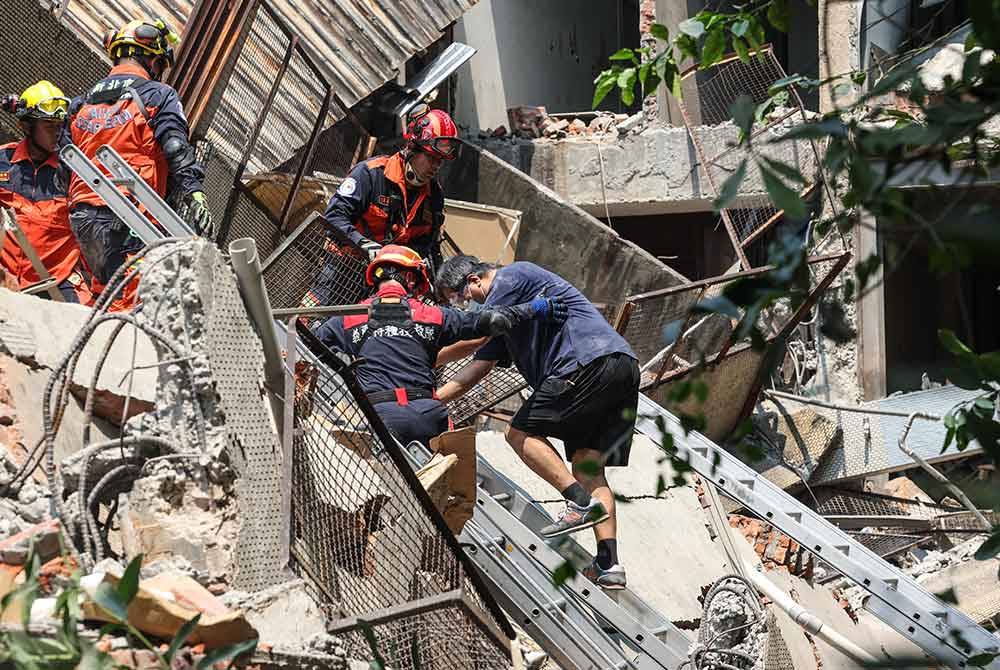 Anggota penyelamat membantu mangsa gempa di sebuah bangunan yang runtuh di bandar New Taipei pada Rabu. Foto AFP