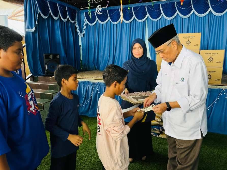 Abdul Aziz menyampaikan sumbangan duit raya sempena program agihan bubur lambuk di Paya Jaras