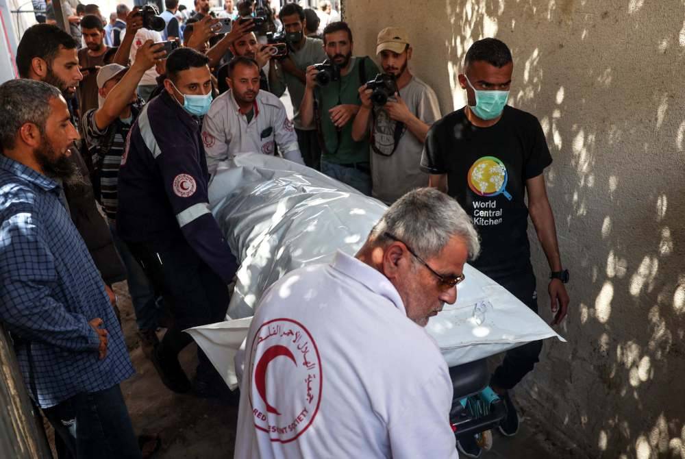 Salah satu mayat kakitangan kumpulan bantuan World Central Kitchen dibawa keluar dari bilik mayat hospital di Rafah di selatan Semenanjung Gaza pada Rabu, dua hari selepas konvoi NGO itu diserang Israel. Foto AFP