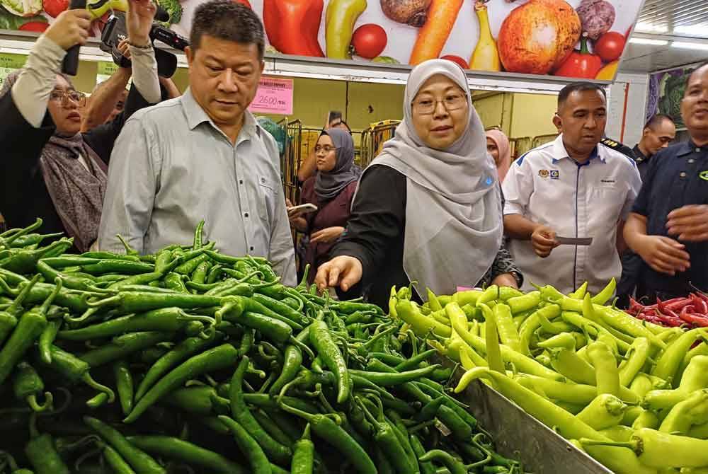 Chong Siang (kiri) dan Fuziah (dua dari kiri) melihat cili kering ketika sesi lawatan dan dan sesi walkabout sempena pelaksanaan SHMMP Hari Raya Puasa 2024 di Pasaraya LYC Sdn Bhd, Kemunting di sini pada Jumaat.