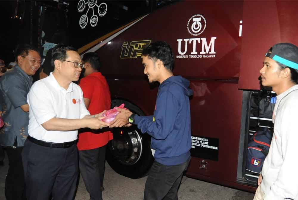 Dr Ahmad Fauzi (dua kiri) menyampaikan pek makanan untuk bersahur kepada penuntut sebelum menaiki bas untuk pulang berhari raya sempena Program Jom Balik Raya di Dataran UTM, Skudai Johor Bahru, pada Khamis.