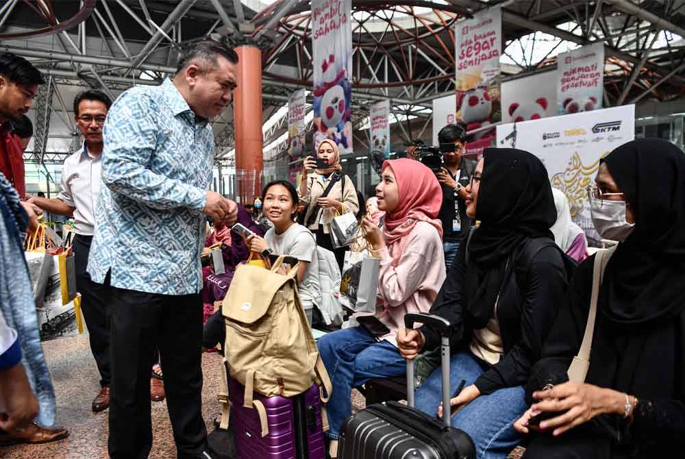 Anthony beramah mesra bersama para penumpang KTMB di KL Sentral pada Jumaat. Foto Bernama