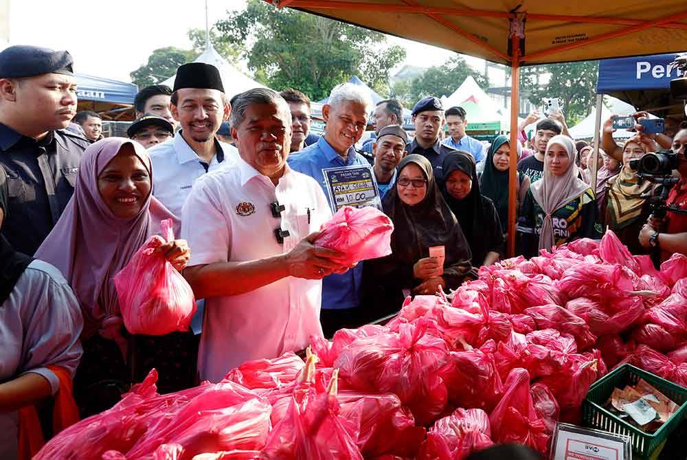 Mohamad menunjukkan ayam segar yang dijual pada harga RM10 seekor pada Majlis Pelancaran Semarak Syawal Agro Madani Peringkat Kebangsaan di Pasar Tani Taman Sri Andalas, pada Sabtu. Foto Bernama