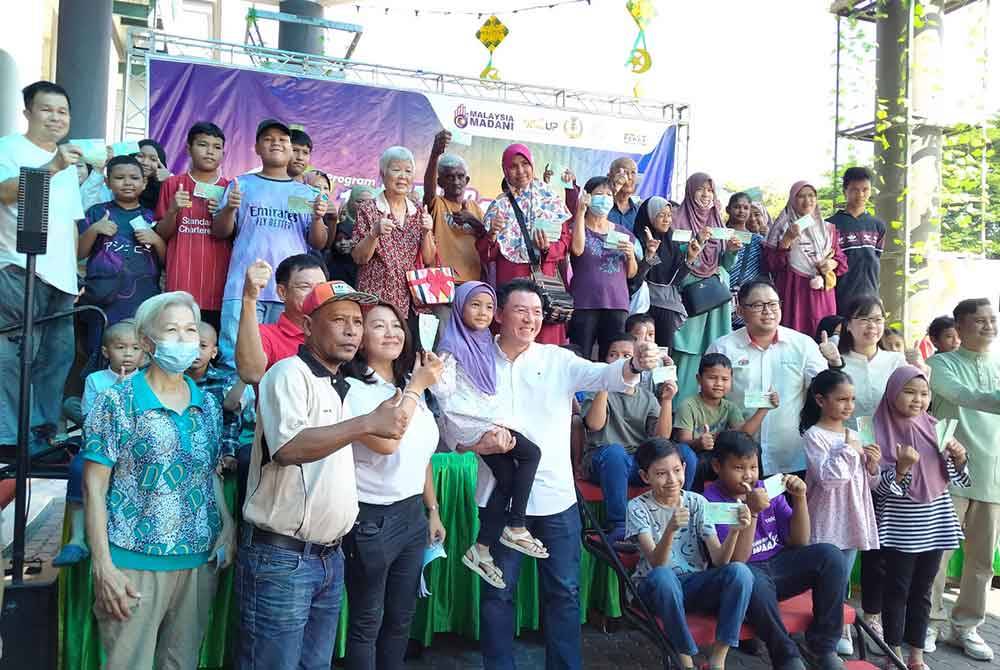 Kor Ming (tiga dari kiri) bersama-sama penerima sumbangan sempena Program Meriah Beraya Sejahtera Bersama DUN Kepayang di sebuah pusat beli-belah pada Sabtu.