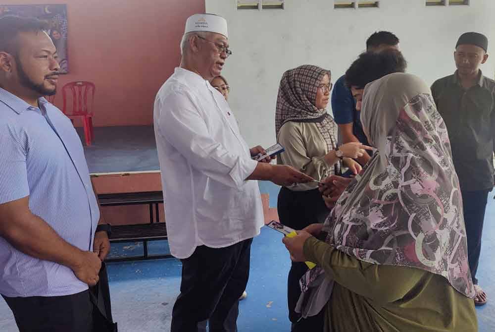 Noh (dua dari kiri) menyampaikan sumbangan kepada salah seorang penerima pada Majlis Penyampaian Sumbangan Anak-Anak Yatim di Gelanggang Futsal Taman Desa Mawar pada Sabtu.