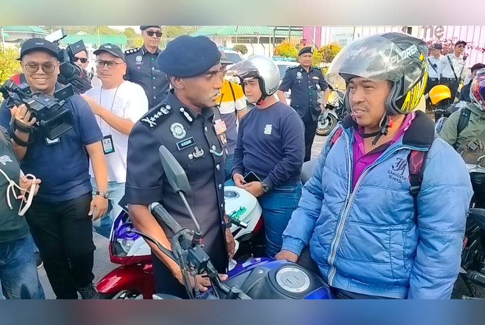 Kumar (kanan) bertanya khabar penunggang motosikal pada Program Advokasi Keselamatan Jalan Raya PDRM dan Perkeso sempena Op Selamat Hari Raya Aidilfitri, di Plaza Tol Kempas pada Sabtu.