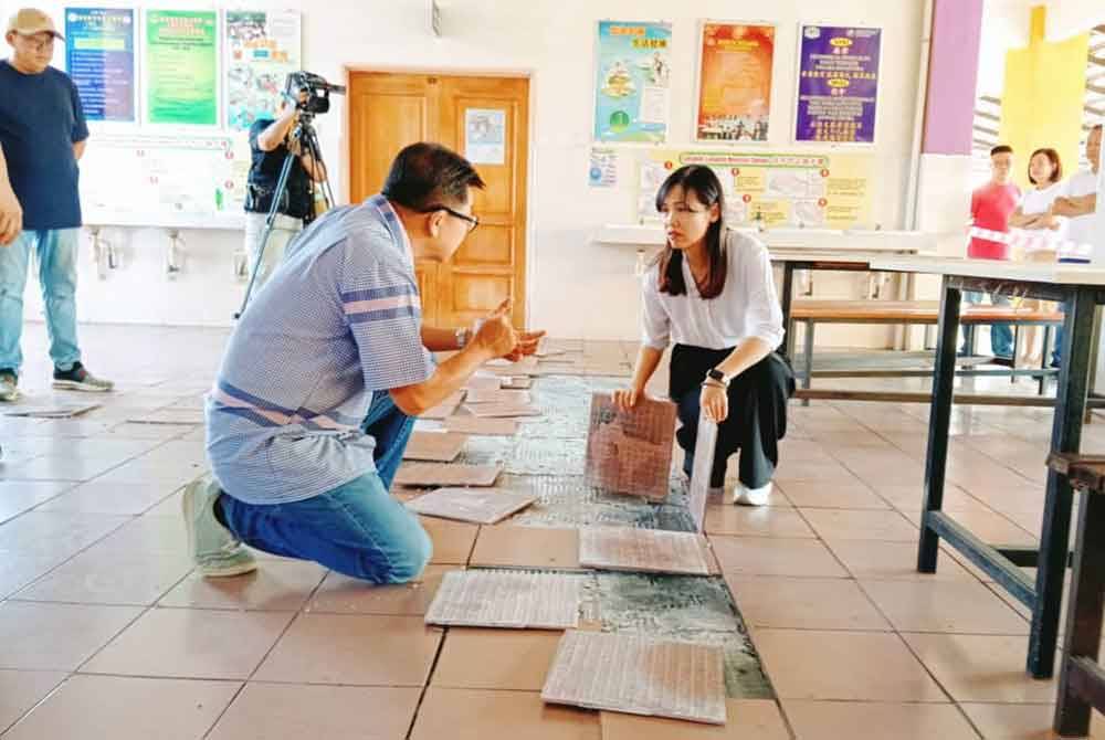 Nie Ching melihat keadaan lantai kantin yang sudah rosak di SJKC Sawit, Kulai pada Sabtu.