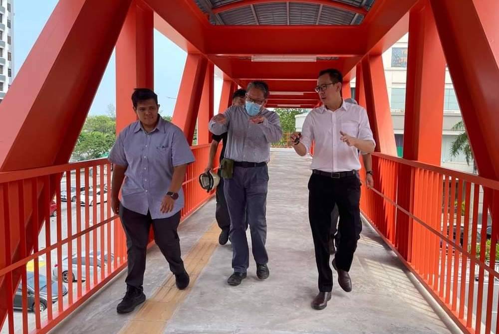 Joshua (kanan) meninjau projek pembinaan jejantas di Pulau Tikus.