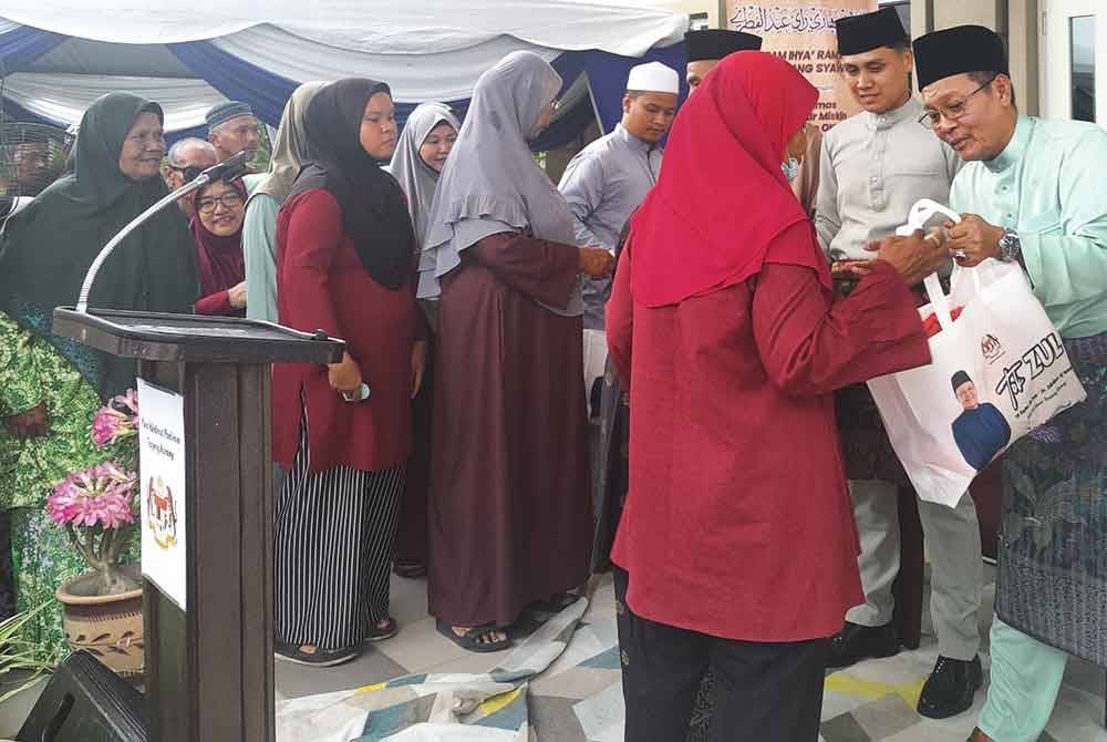 Zulkafperi (kanan) menyampaikan sumbangan kepada penerima pada Program Ihya Ramadan di Pusat Latihan dan Khidmat Masyarakat Universiti Kebangsaan Malaysia (UKM), Kampung Sungai Kajang di sini pada Ahad.