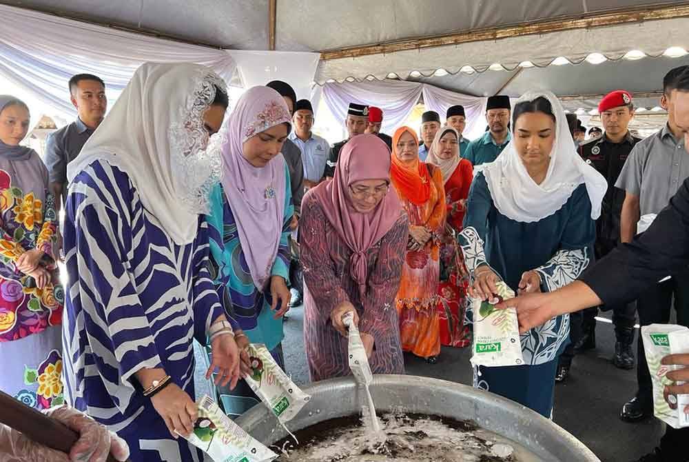 Tunku Azizah (tengah) bersama Sultanah Nur Zahirah (dua, kiri) dan puteri Terengganu mencemar duli memasak bubur lambuk untuk diagihkan kepada penghuni Penjara Marang.