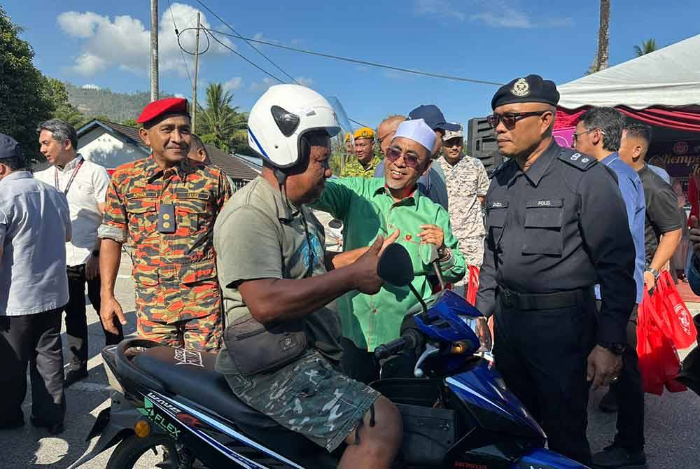 Abd Rahman (tengah) ketika Kempen Keselamatan Jalan Raya oleh Majlis Keselamatan Jalan Raya (MKJR) di hadapan Balai Polis Bukit Yong pada Isnin.