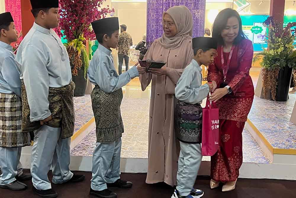 Fauziah (dua dari kanan) dan Alice (kanan) menyampaikan sumbangan dan duit raya kepada anak-anak Anak-anak yatim dan asnaf dari Rumah Raudhatul Al-Faeez, Gombak.