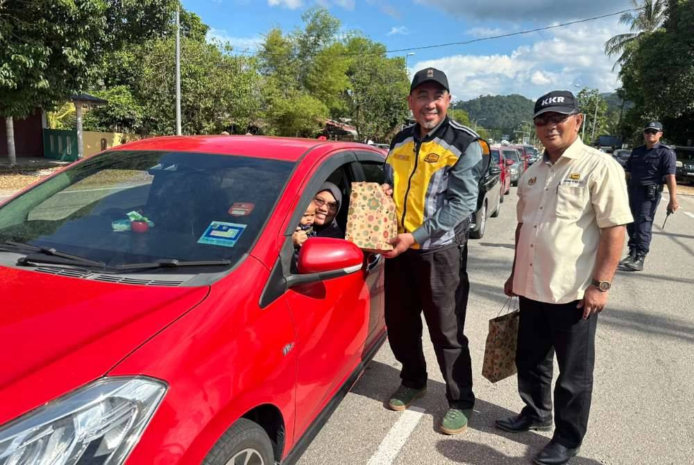 Dr Izani (tengah) bersama Ir Mohd Suhaili (kanan) menyampaikan sumbangan kepada perantau yang tiba di Kelantan pada Isnin.