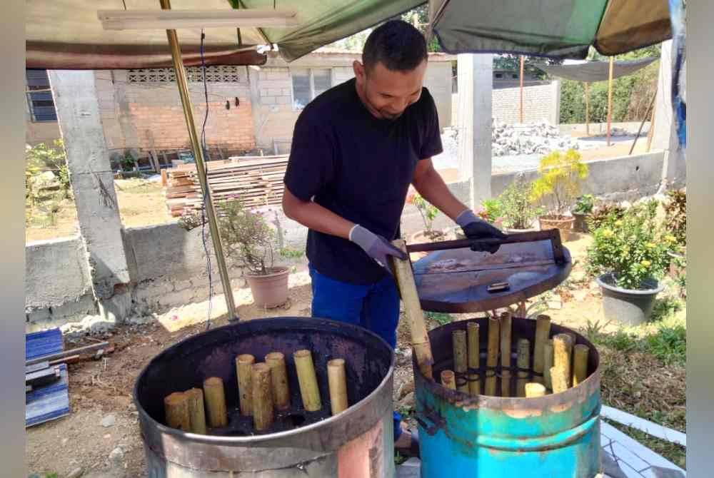 Ahmad Hishamudin menunjukkan lemang yang dimasak menggunakan kaedah moden.