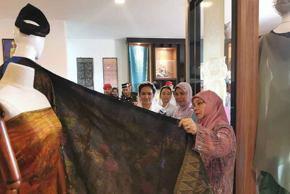 Tunku Azizah (kanan) ketika melihat songket yang dihasilkan.