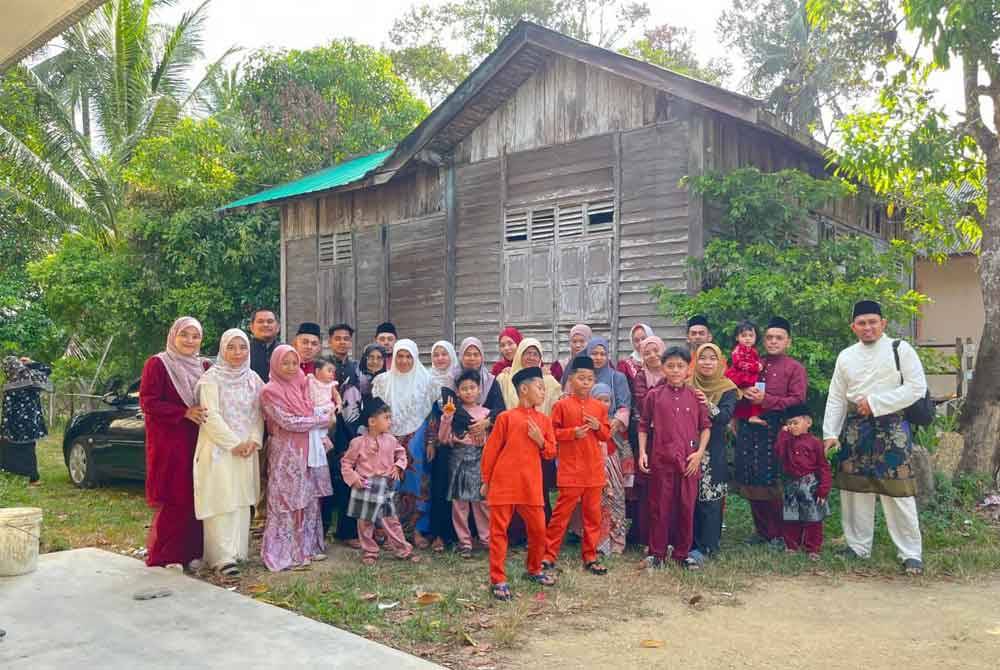 Mohd Naizul merakam gambar bersama ahli keluarga besarnya di rumah usang neneknya di Kampung Jambu Merah, Melor.