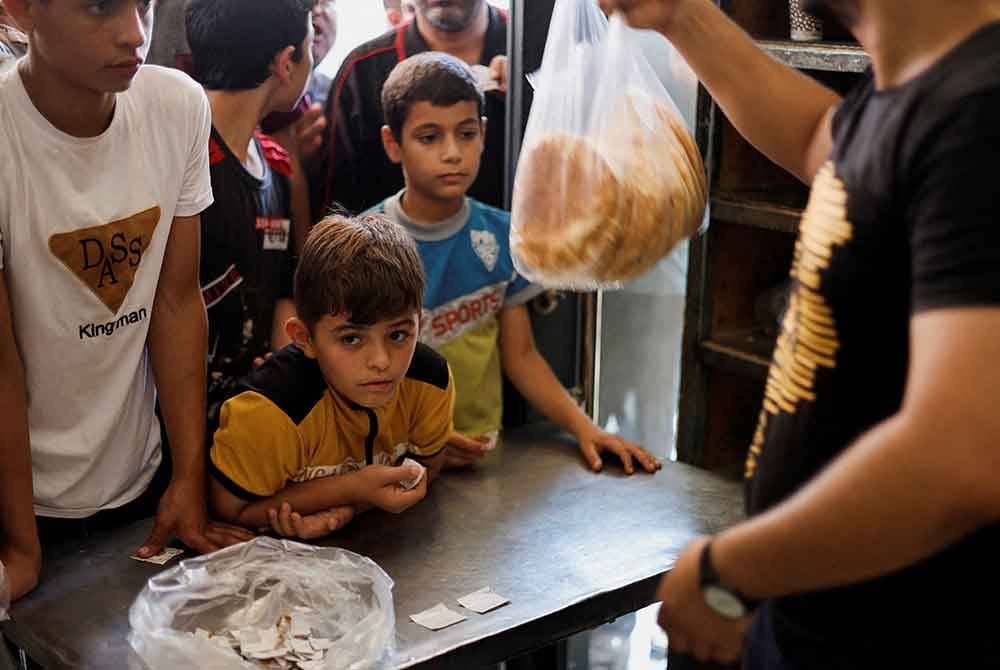 Ribuan orang hadir untuk membeli makanan sejurus selepas pengumuman dibuat bahawa roti akan dijual di kedai roti di Bandar Gaza - Foto: Reuters