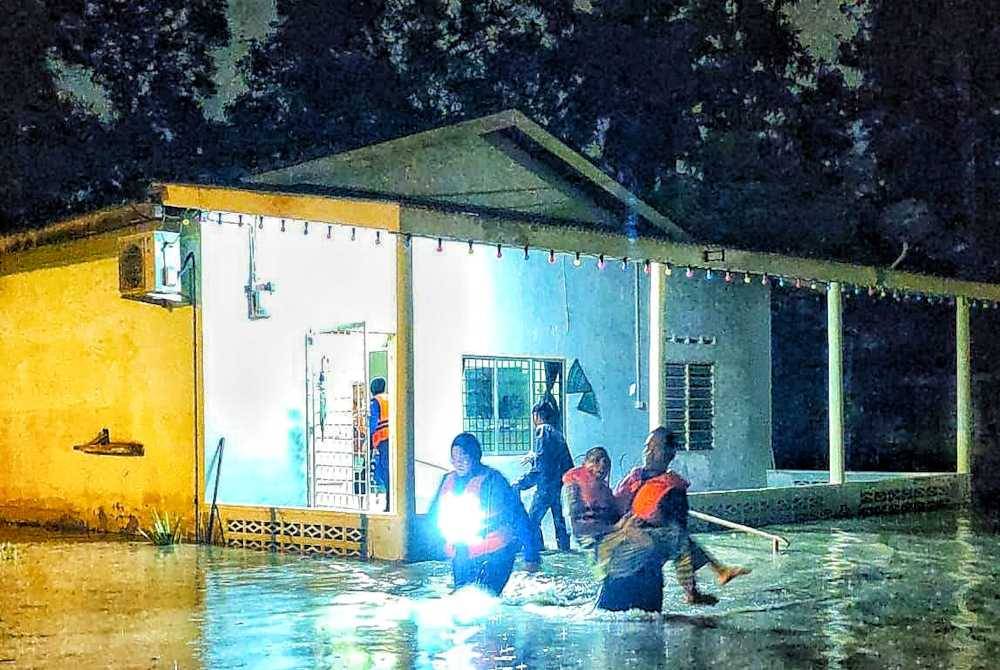 Angkatan Pertahanan Awam (APM) membantu memindahkan mangsa banjir di Kampung Padang Kerbau pada Selasa.