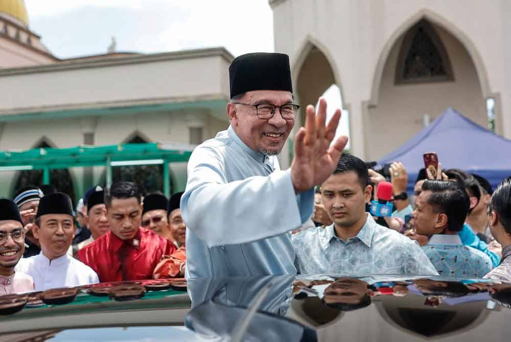 Perdana Menteri Datuk Seri Anwar Ibrahim melambai tangan selepas menunaikan solat Jumaat bersama rakyat di Masjid Bandar Utama Batang Kali baru-baru ini. Foto Bernama