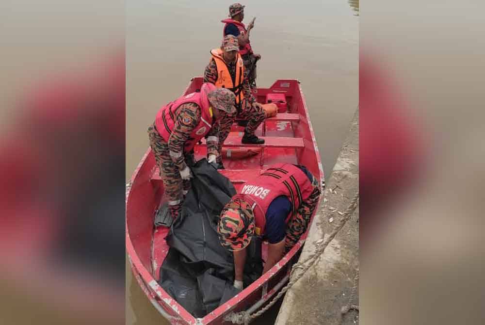 Anggota bomba mengangkat mayat mangsa di sungai berdekatan Jalan Bagan Sungai Yu, Pasir Penambang, Kuala Selangor pada Rabu.