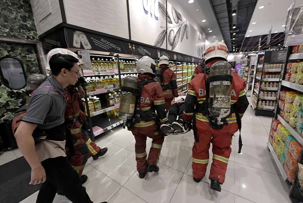 Anggota JBPM membawa keluar mangsa dari kawasan kebakaran untuk menerima rawatan ketika latihan kebakaran Rancangan Pra-Insiden Aeon Mal, Seksyen 13 oleh JBPM pada Rabu. Foto Bernama