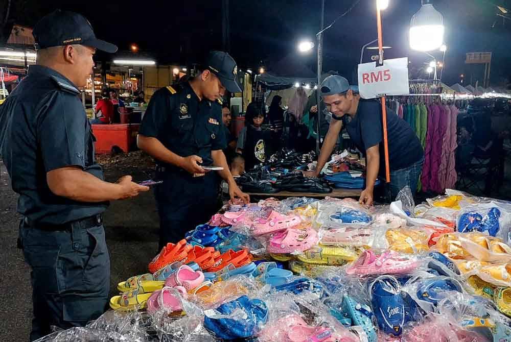 Pegawai KPDN Pahang memeriksa barangan yang dijual bagi memastikan peniaga mematuhi harga. Foto KPDN Pahang